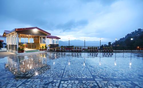 a pool at a hotel with lights on the ground at Hotel Vishnu Palace in Mussoorie