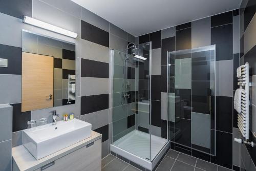 a bathroom with a sink and a shower at Hotel Kamilla in Balmazújváros