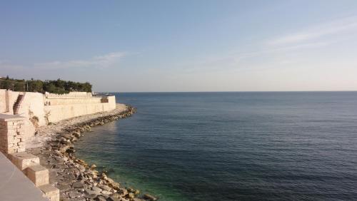 a stone retaining wall next to the ocean at Casa Vacanze La Scalinata in Bisceglie