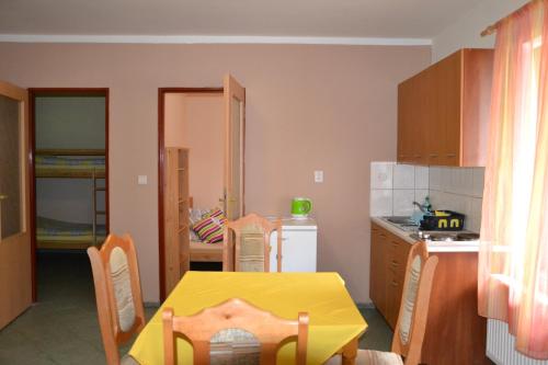 a kitchen with a table and a yellow table and chairs at Zrcadlová Koza in Turnov