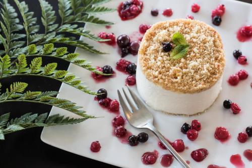 a piece of cake on a white plate with berries at U Boutique Kinneret by the Sea of Galilee in Tiberias