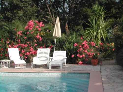 - un groupe de chaises et un parasol à côté de la piscine dans l'établissement le studio bleu, à Tourtour