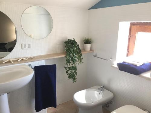 un bagno con lavandino, WC e specchio di Blu Marea a Macari