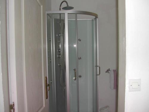 a glass shower in a bathroom with a mirror at le studio bleu in Tourtour