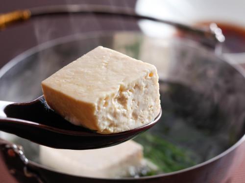 a piece of tofu on a spoon in a wok at Asan Kotonami in Manno