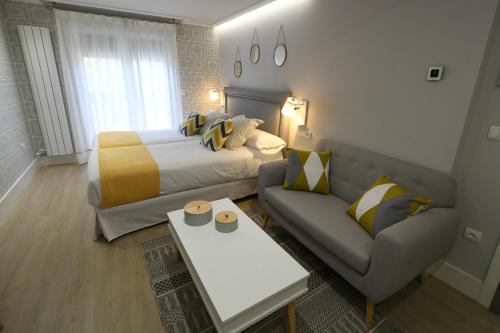 a hotel room with a bed and a couch at LEÓN SUITE Urban Studios in León
