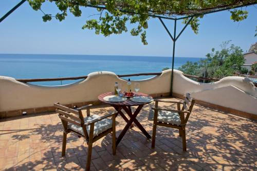 a table and chairs on a patio with a view of the ocean at Casa Paradiso - Panoramic Sea View & Jacuzzi in Terracina