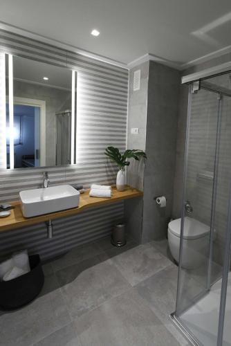 a bathroom with a sink and a toilet and a mirror at LEÓN SUITE Urban Studios in León