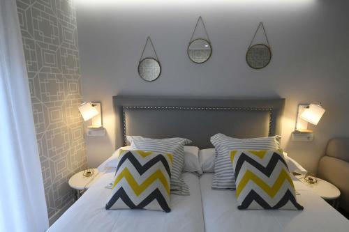 a bedroom with a bed with two pillows and two lamps at LEÓN SUITE Urban Studios in León