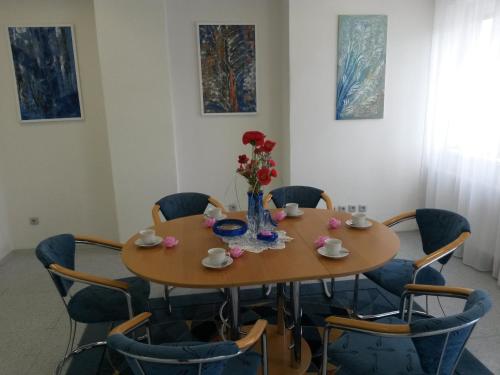 a table with chairs and a vase of flowers on it at Ubytovna Kubra in Hodonín