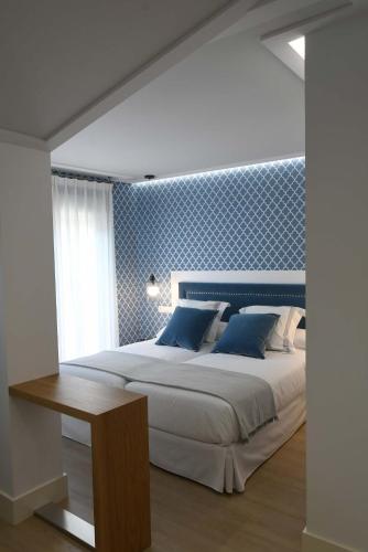 a bedroom with a large bed and a wooden table at LEÓN SUITE Urban Studios in León