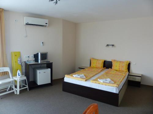 a bedroom with a bed and a desk and a tv at Studio S - Vasiliko in Tsarevo