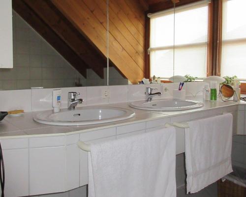 a bathroom with two sinks and two white towels at Gästezimmer Paul in Lindau