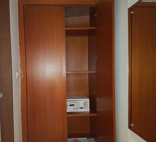a closet with a cabinet with a radio in it at The Sun Hotel & Spa Legian in Legian
