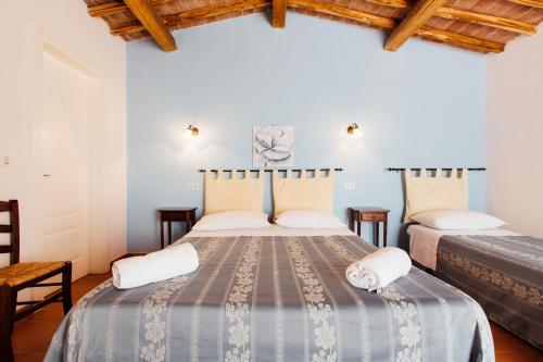 two beds in a room with wooden ceilings at Agriturismo La Quercia in SantʼAntonio