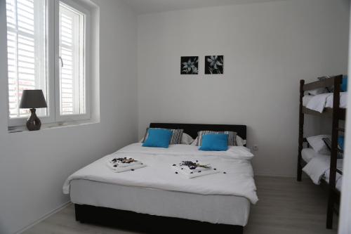 a white bedroom with a large bed with blue pillows at Apartment Nijona in Trebinje