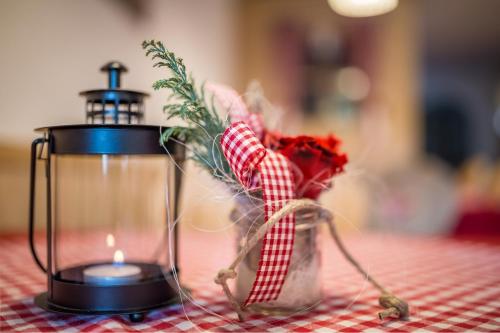 a candle and flowers on a table next to a blender at Berggasthaus Agritur Moserhof in Braies