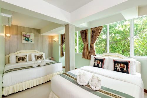 two beds in a room with stuffed animals on them at RoomQuest Suvarnabhumi Airport Romklao Soi 6 in Lat Krabang