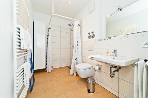 a white bathroom with a sink and a toilet at Braviscasa - Ferienresidenz Stadttor Endingen in Endingen