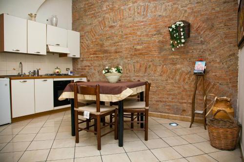 cocina con mesa y pared de ladrillo en B&B Garibaldi, en Catania