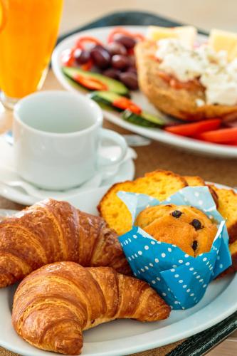 ein Teller mit Croissants und Gebäck auf einem Tisch in der Unterkunft Christina Beach Hotel in Chania