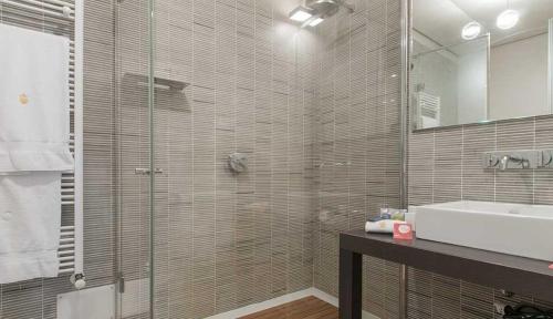 a bathroom with a shower and a sink and a mirror at Milan Royal Suites - Centro in Milan