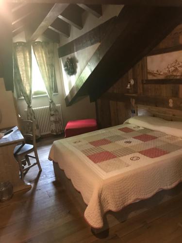 アオスタにあるLa Meizon de Saraのベッドルーム1室(チェック入りの毛布付きのベッド1台付)