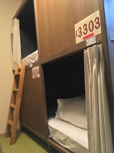 a bunk bed with a ladder and a bunk bed in a room at Tokyo Guest House Itabashi-juku in Tokyo