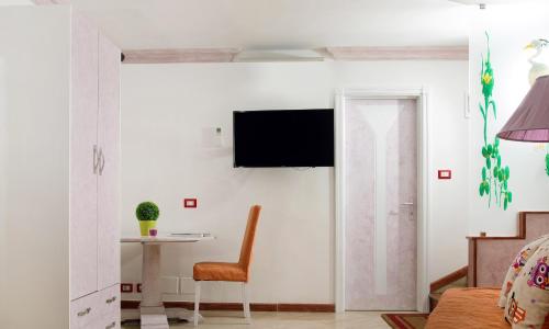 a living room with a table and a television on a wall at Capri Dreaming in Anacapri