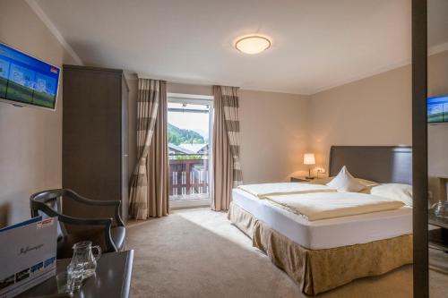 a hotel room with a bed and a balcony at Sporthotel Austria in Sankt Johann in Tirol