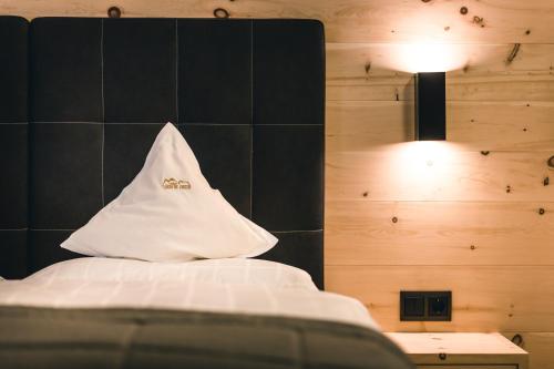 a bedroom with a bed with a white pillow at Lüch de Costa in Colfosco