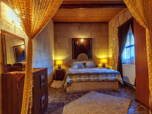 een slaapkamer met een bed en een spiegel bij Adanos Konuk Evi in Avanos
