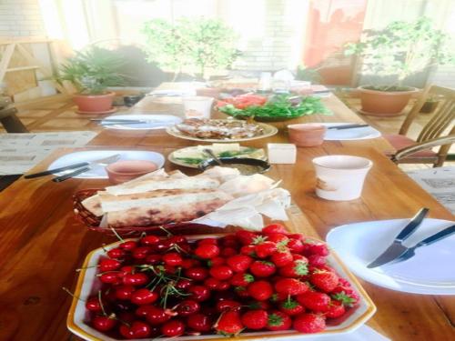 a table with a plate of food with strawberries on it at Family Mini-Hotel Martirosyan's and tours in Yerevan