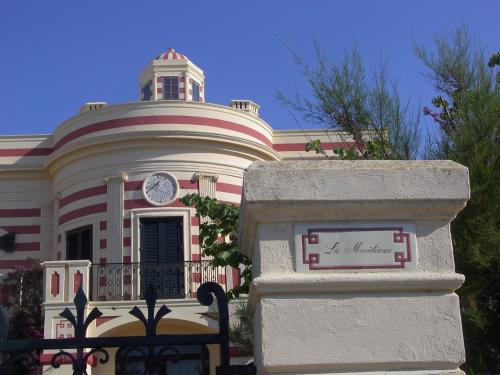 a building with a clock tower on top of it at Villa La Meridiana - Caroli Hotels in Leuca