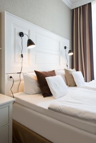 a white bed with two lamps on top of it at Hotel Stralsund in Stralsund