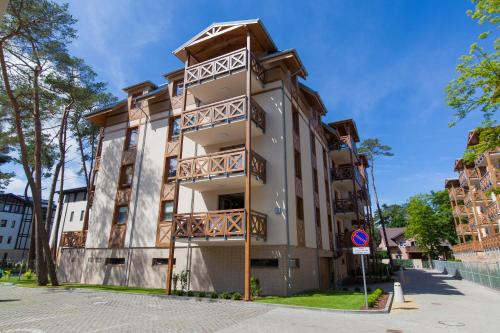 an apartment building with balconies on a street at Rezydencja Park - City Apartments in Mielno