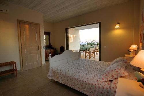a bedroom with a bed and a door to a patio at Ideales Resort in Trapezaki