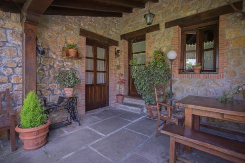 a porch of a stone house with potted plants at Casa Solallosa 112 in Quijas