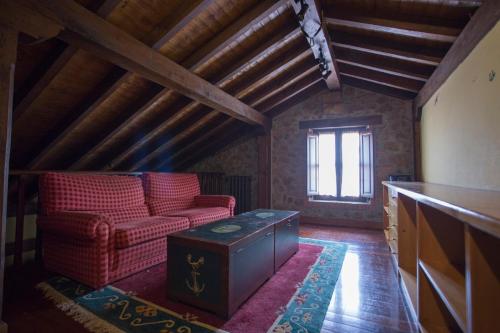 a living room with a red chair and a table at Casa Solallosa 112 in Quijas