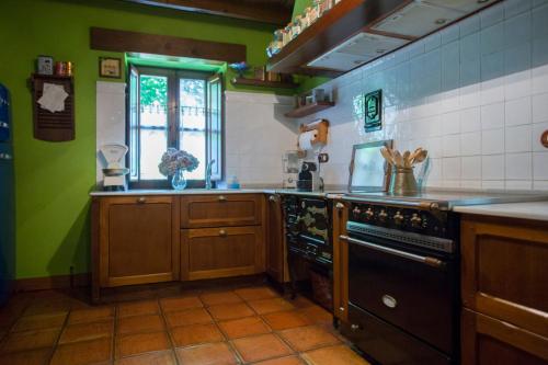 a kitchen with a stove and a window at Casa Solallosa 112 in Quijas