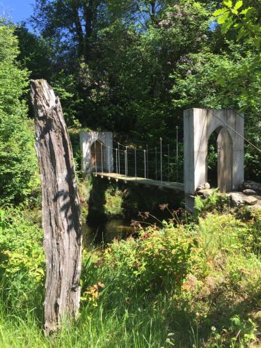 a bridge over a river with a tree stump at Ballyteige Lodge in Ballyteige Bridge