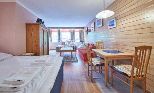 um quarto com uma cama, uma mesa e cadeiras em Appartements Alpin em Saalbach-Hinterglemm