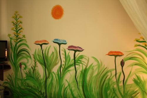 a wall with a mural of flowers and grass at Villa Clementine in Piazza Armerina