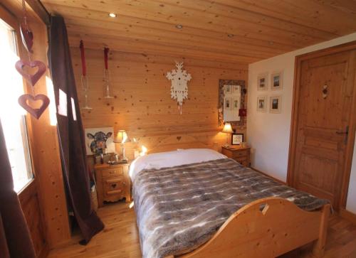 a bedroom with a bed in a log cabin at 65m2 - balcon et vue sur les Aravis in La Giettaz