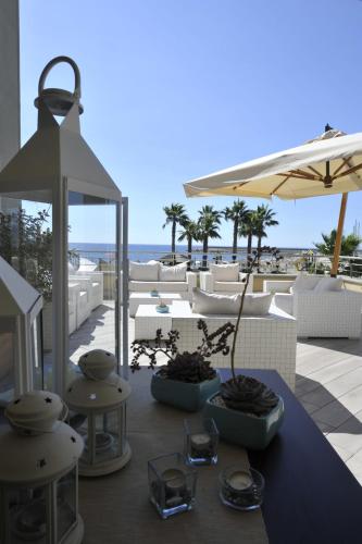 a patio with a table and chairs and the ocean at Aregai Marina Hotel & Residence in Santo Stefano al Mare