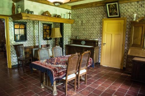a dining room with a table and chairs and a fireplace at B&B Erve de Bosch in Benteloo