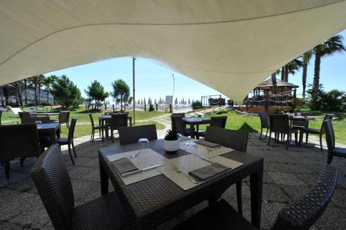 a restaurant with tables and chairs under a tent at Aregai Marina Hotel & Residence in Santo Stefano al Mare