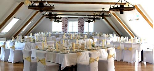 a room filled with tables and chairs with white table linen at Hotel-Gasthof Zur Post in Velburg