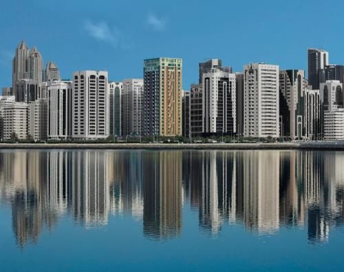 a city skyline with buildings and a body of water at Hala Arjaan by Rotana, Deluxe Hotel Apartments in Abu Dhabi