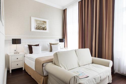 a hotel room with a bed and a couch at Hotel Stralsund in Stralsund